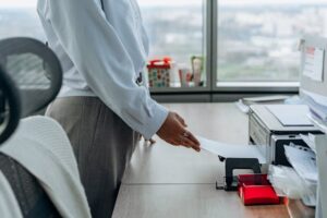 vrouw zet printpapier in printer